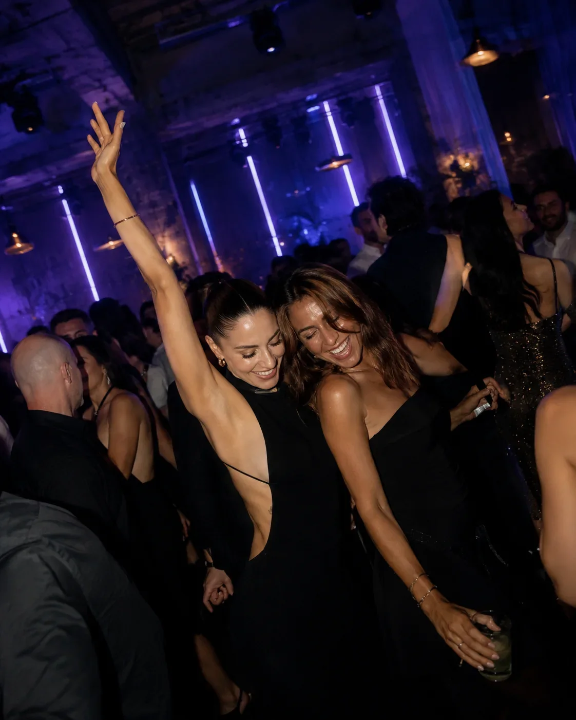Zwei Freundinnen tanzen lachend und ausgelassen gemeinsam durch die NOCTRA-Clubnacht.