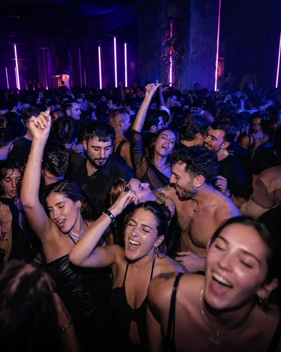 Ausgelassene Partygäste feiern dicht gedrängt und verlieren sich gemeinsam in der Nacht.